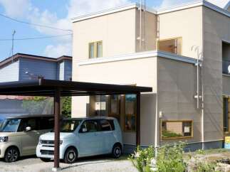 Discover this charming property featuring a modern two-story house with a light beige exterior and a sleek black carport.