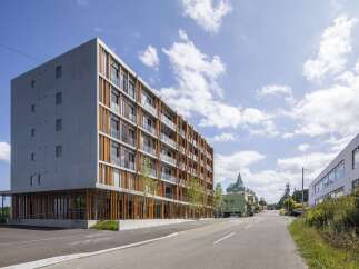 Discover modern living in this striking apartment building, featuring a unique facade with vertical wooden accents and expansive glass balconies.