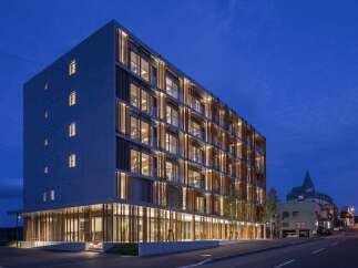 Experience modern living in this stunning multi-story building, featuring a unique facade with vertical wooden louvers and expansive windows that offer abundant natural light.