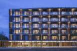 Experience modern living in this stunning multi-story building, featuring a unique facade with vertical wooden louvers and ample glass balconies.