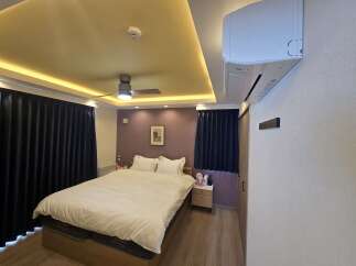 Experience modern comfort in this stylish bedroom, featuring a plush bed with crisp white linens and a sleek ceiling fan for optimal air circulation.