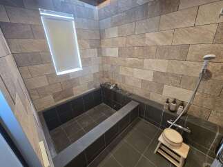 Experience ultimate relaxation in this luxurious bathroom featuring a deep soaking tub and a modern shower system.
