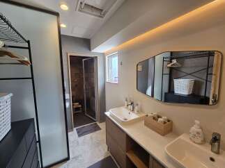Experience modern comfort in this beautifully appointed bathroom, featuring a sleek vanity with dual sinks and ample storage.