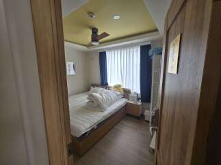 Discover this cozy bedroom featuring a comfortable bed with crisp white linens and a plush duvet, perfect for relaxation.