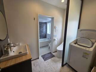 This modern bathroom features a sleek vanity with a white sink and a chrome faucet, complemented by a large oval mirror.