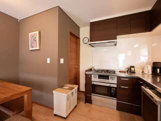 Discover this modern kitchen featuring sleek dark wood cabinetry and a stainless steel countertop.