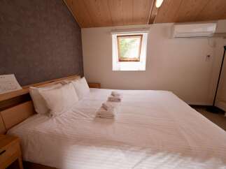 Experience comfort and style in this inviting bedroom, featuring a plush king-sized bed adorned with crisp white linens and fluffy pillows.