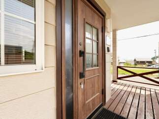 Step into this charming home featuring a beautiful wooden front door with a glass pane, perfect for letting in natural light.