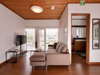 Experience modern living in this beautifully appointed living space, featuring a plush sectional sofa and an ottoman perfect for relaxation.