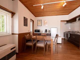 This charming kitchen and dining area features a warm, wood-paneled ceiling and rich hardwood floors, creating a cozy and inviting atmosphere.