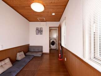 Discover a unique living space featuring a cozy floor-level seating area with comfortable cushions and a plush grey sofa.