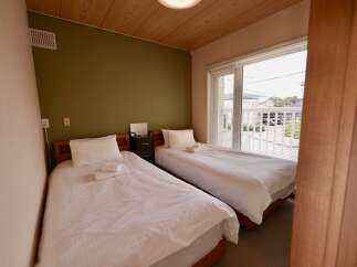 This inviting hotel room features two comfortable twin beds, perfect for solo travelers or friends sharing a space.