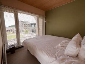 Experience comfort and style in this inviting bedroom, featuring a plush bed adorned with crisp white linens and neatly folded towels.