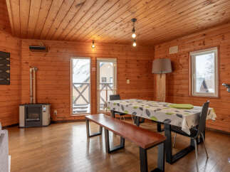 Experience cozy living in this charming wooden cabin, featuring a spacious dining area perfect for family gatherings.