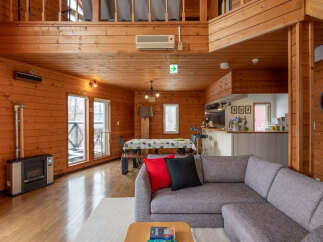 Experience cozy living in this charming wooden cabin, featuring a spacious open-plan living and dining area perfect for gatherings.