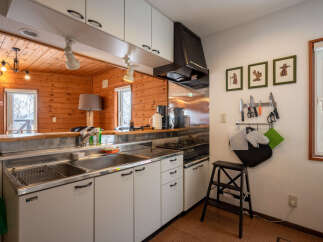 Experience cozy living in this charming kitchen featuring warm wood paneling and a functional layout.