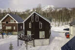 Experience the charm of a winter wonderland with these picturesque chalets nestled in a snowy landscape.