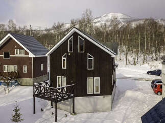 Experience the charm of a winter wonderland with these picturesque chalets nestled in a snowy landscape.