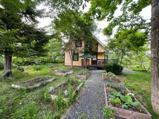 Discover this charming home nestled amidst lush greenery and a thriving garden.