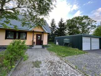 Discover this charming property featuring a cozy peach-colored house with a welcoming front porch and a durable grey shingle roof.