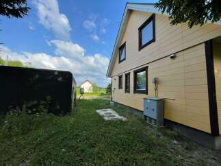 Discover this charming property featuring a light yellow siding house with dark trim windows, perfect for a serene getaway.