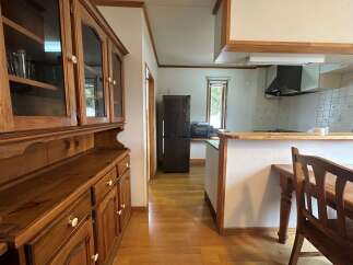 This charming kitchen features a beautiful wooden hutch with glass-front cabinets, perfect for displaying your dinnerware.