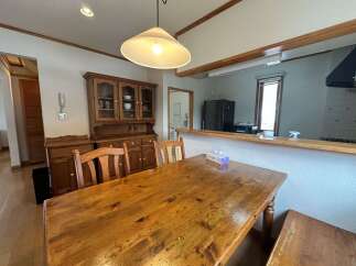 This charming dining area features a rustic wooden dining table and chairs, perfect for family meals.