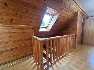 Experience rustic charm in this attic space, featuring warm wooden paneling throughout and a charming skylight that floods the area with natural light.