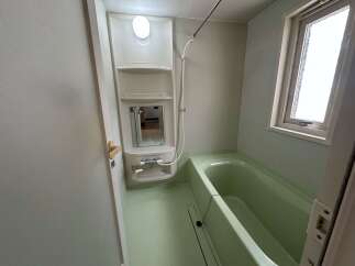 This bathroom features a light green bathtub and matching floor, creating a cohesive and calming aesthetic.