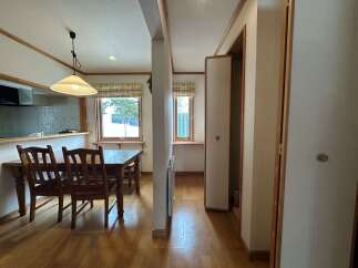Enjoy cozy meals in this charming dining area featuring a wooden table and chairs, perfect for family gatherings.