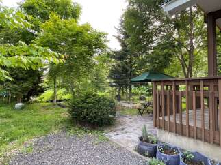 Enjoy outdoor living in this charming backyard featuring a wooden deck, perfect for entertaining or relaxing.