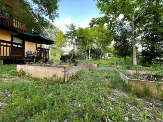 Discover a charming retreat with a beautiful wooden deck and an inviting outdoor dining area, perfect for enjoying the serene natural surroundings.