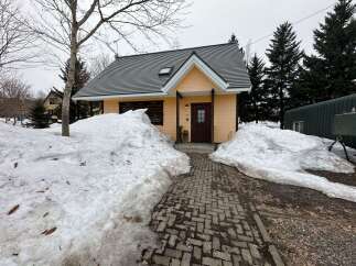 Charming yellow cottage nestled amidst snow-covered landscapes, perfect for a winter retreat.