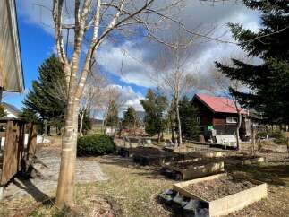 Discover this charming property featuring a rustic wooden cabin with a bright red roof, nestled amidst a serene natural landscape.