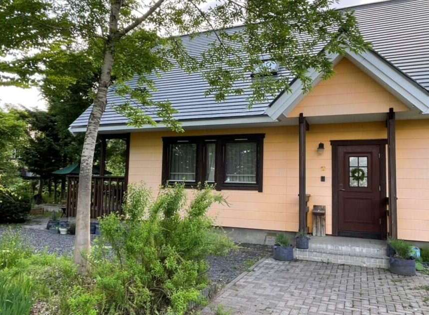 Discover this charming peach-colored house nestled amidst lush greenery and mature trees.