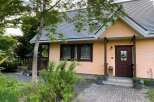 Discover this charming peach-colored house nestled amidst lush greenery and mature trees.