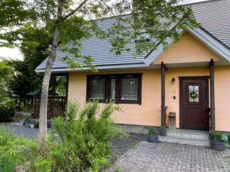 Discover this charming peach-colored house nestled amidst lush greenery and mature trees.
