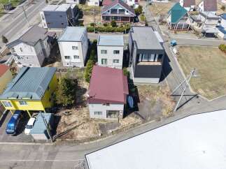 Discover this charming property featuring a unique yellow house with a distinctive blue van and white car parked nearby.