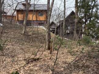 Nestled amidst a serene forest, this property features two charming wooden houses, perfect for a secluded getaway or a unique rental opportunity.
