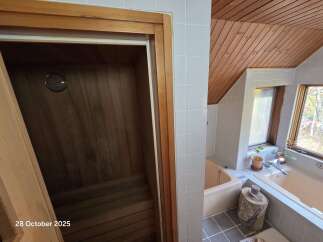 Experience ultimate relaxation in this luxurious bathroom featuring a private sauna and a spacious bathtub.