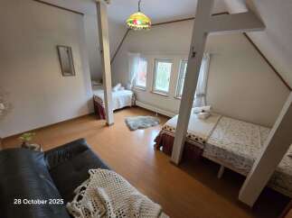 Discover a cozy attic bedroom featuring two comfortable beds, perfect for accommodating guests.