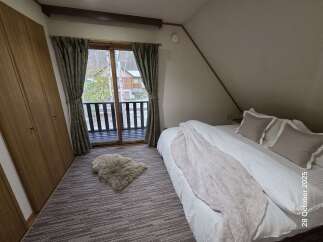 Experience cozy living in this charming bedroom featuring a comfortable bed adorned with plush blankets and accent pillows.