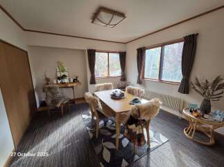 Experience cozy dining in this charming room, featuring a light wood table surrounded by plush, fur-covered chairs.