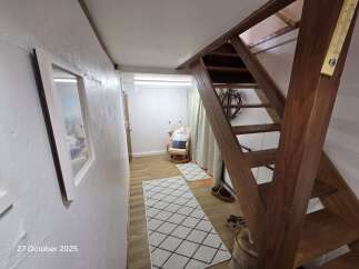 Discover this charming space featuring a rustic wooden staircase leading to an upper level.