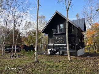 Discover this unique black A-frame lodge nestled amidst vibrant autumn foliage.