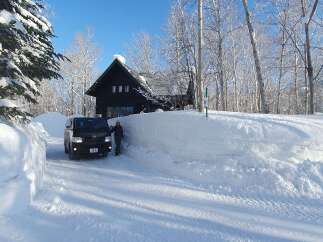 Escape to a winter wonderland with this charming cabin nestled amidst snow-covered trees.
