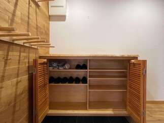Discover this charming entryway featuring a modern wooden shoe cabinet with louvered doors, perfect for organizing footwear.