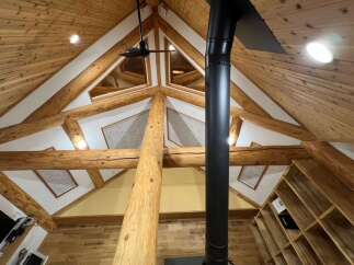Experience rustic charm in this stunning A-frame cabin featuring exposed wooden beams and a vaulted ceiling.