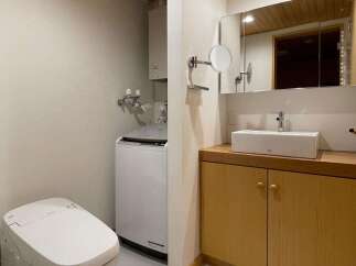Discover this modern bathroom featuring a sleek white toilet and a convenient washing machine.