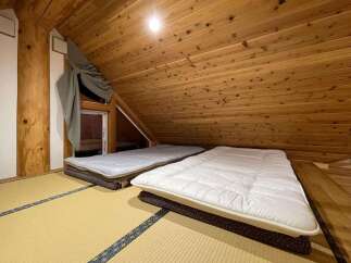 Experience cozy living in this charming attic room, featuring traditional tatami flooring and comfortable futon beds.